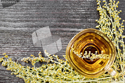 Image of Tea of gray wormwood in glass cup on board top