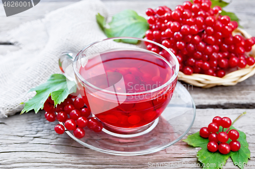 Image of Tea from viburnum in cup with berries on old board