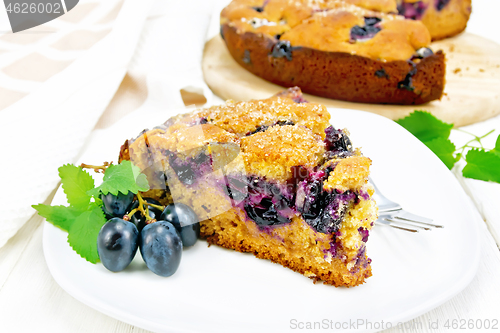 Image of Pie with black grapes  in plate on board