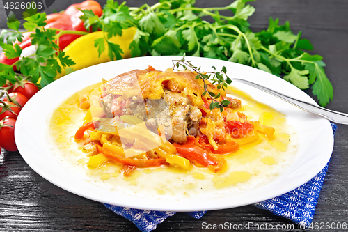 Image of Chicken with pepper in white plate on dark board