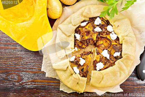 Image of Pie with pumpkin and onions on dark board top