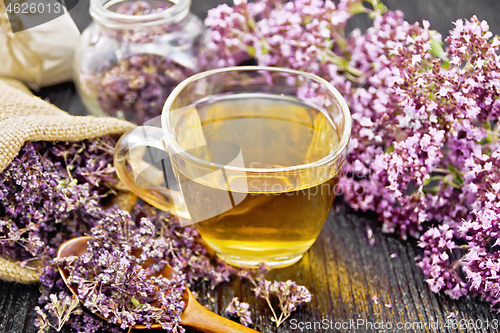 Image of Tea of oregano in cup with spoon on board