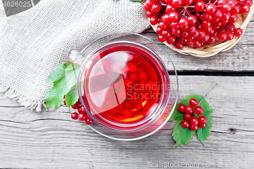 Image of Tea from viburnum in cup with berries on old board top