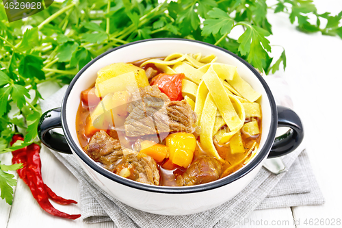 Image of Lagman in bowl on light wooden board