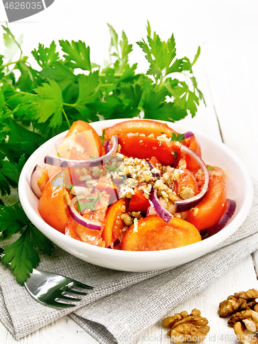 Image of Salad with tomato and walnut in plate on white board