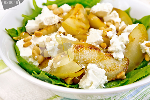 Image of Salad from pear and spinach in dish on napkin