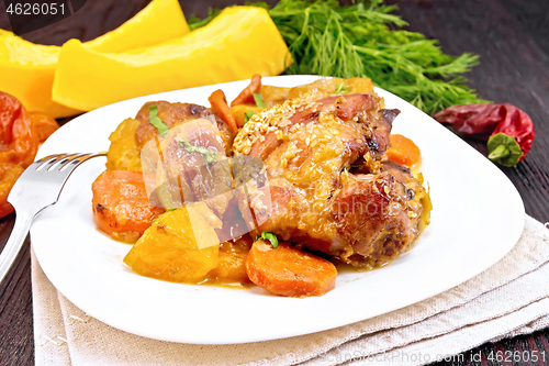 Image of Chicken roast with pumpkin and carrots on dark board