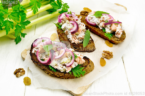 Image of Bruschetta with fish and curd on wooden board