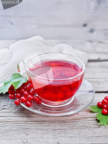 Image of Tea from viburnum in cup with berries on old wooden board