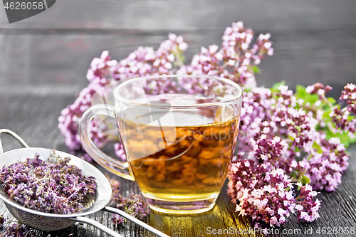 Image of Tea of oregano in cup with strainer on board