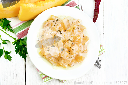 Image of Pumpkin with sour cream sauce in plate on board top