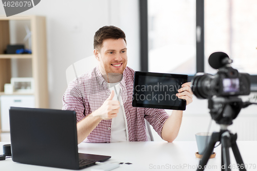 Image of male blogger with tablet computer videoblogging