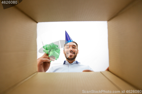 Image of happy man opening parcel box or birthday gift