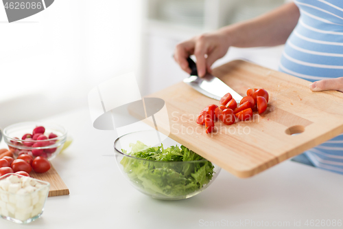 Image of close up of pregnant woman cooking food at home