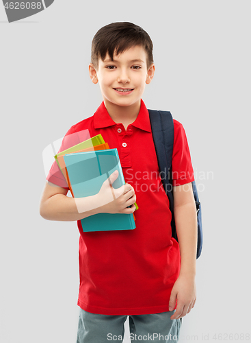 Image of smiling schoolboy with books and school bag
