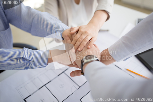 Image of close up of business team stacking hands