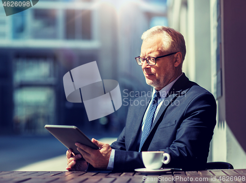 Image of senior businessman with tablet pc drinking coffee