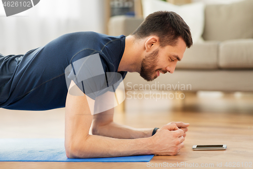 Image of man doing plank exercise at home