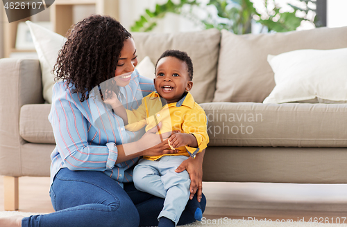 Image of happy african american mother with baby at home