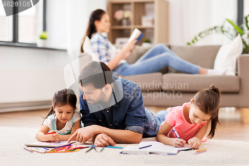 Image of father with little daughters drawing at home