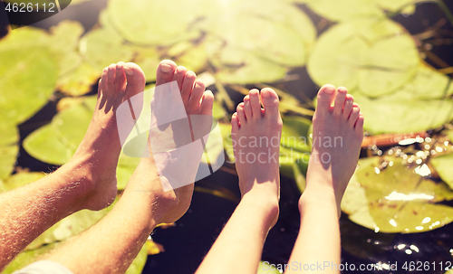 Image of grandfather and grandson feet over river