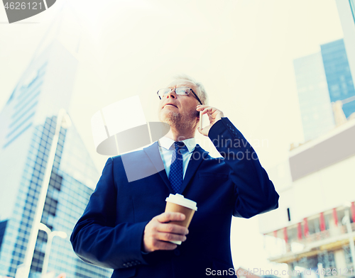 Image of senior businessman calling on smartphone in city