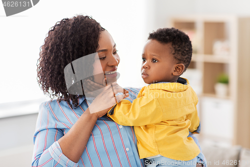 Image of happy african american mother with baby at home