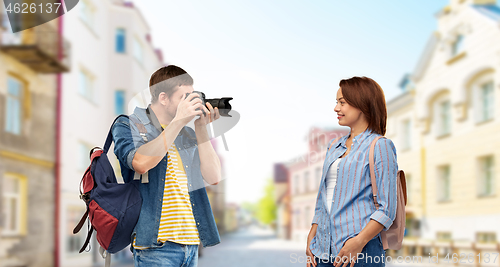 Image of happy couple of tourists with backpacks and camera