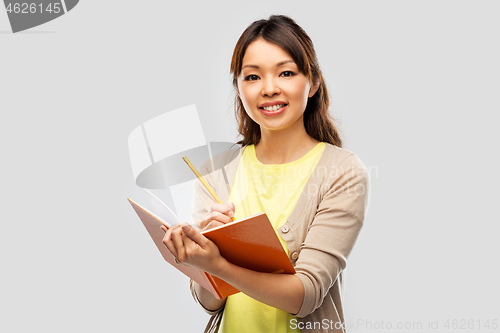 Image of asian student woman with books and pencil