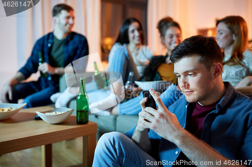 Image of man with smartphone at home party
