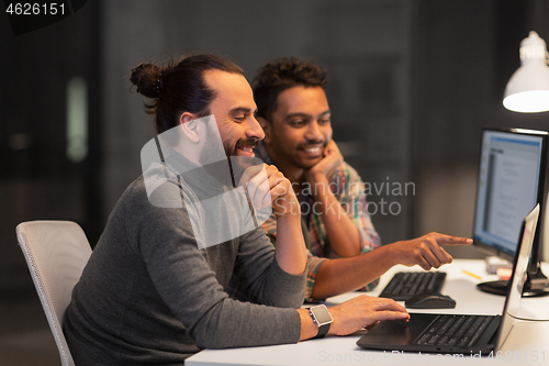 Image of creative team with computer working late at office