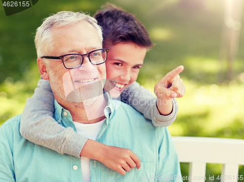 Image of grandfather and boy pointing finger at summer park