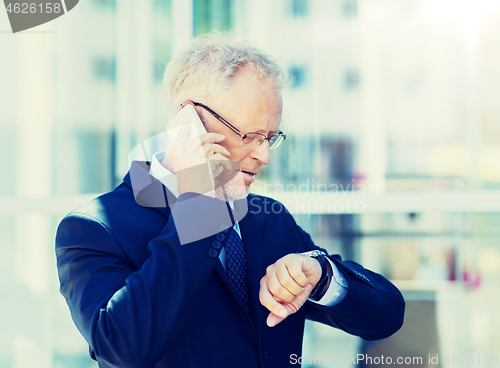 Image of senior businessman calling on smartphone in city