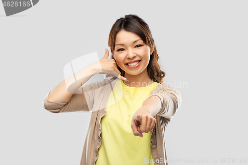 Image of african asian making phone call gesture