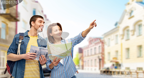 Image of happy couple of tourists with city guide and map