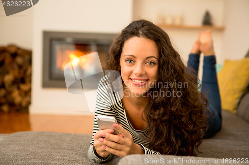 Image of Woman with her cellphone at home