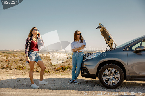 Image of Girls with a broken a car on country road