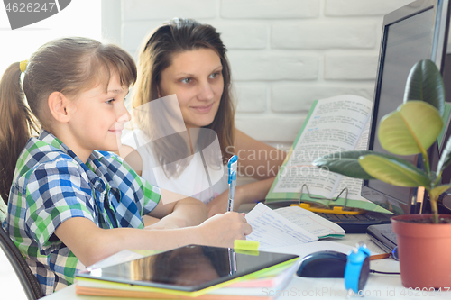 Image of Mom helps daughter learn at home at the computer