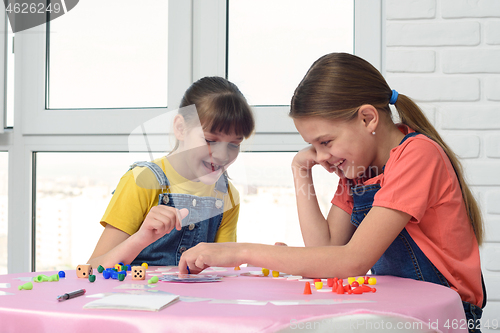 Image of Two girls having fun playing a board game