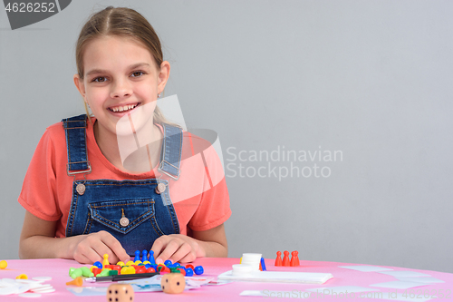 Image of Girl sitting at the table playing board games, free space on the right