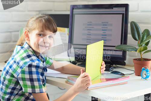 Image of Girl enjoys doing homework at the computer