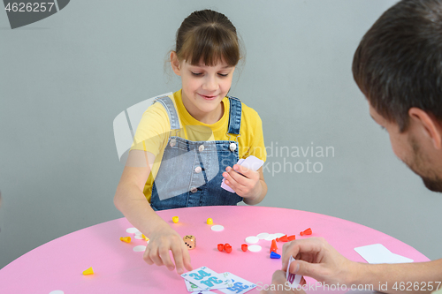 Image of Girl playing card board games with dad