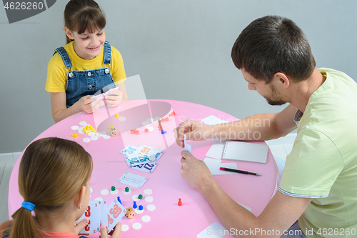 Image of Family plays board games at the table, top view