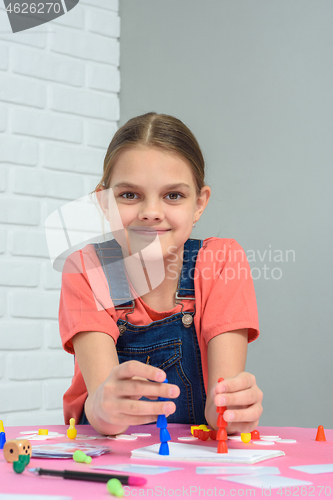 Image of Girl plays board games, sits at a table at home