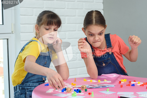Image of Girls play board games, one of them looks funny at the chips