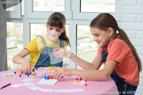 Image of Two happy girls spend home leisure playing games