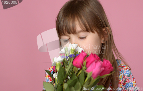 Image of Cute young adorable girl holding and smell bouquet of fresh flowers