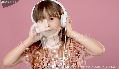 Image of Cute little girl posing and dancing with headphones while listen to the music