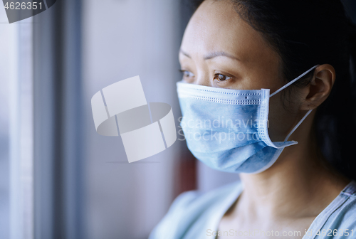 Image of Woman staying at home wearing protective surgical mask