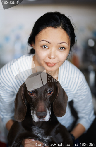 Image of Woman at home hugging her dog